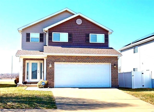 traditional-style home featuring fence, driveway, brick siding, a garage, and a shingled roof