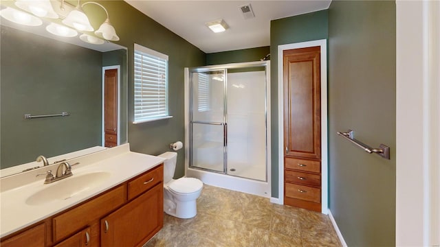 bathroom with a shower with door, vanity, toilet, and tile patterned floors