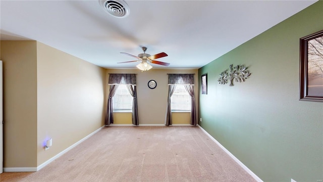 unfurnished room featuring a ceiling fan, light colored carpet, and baseboards