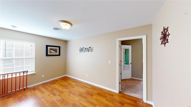 unfurnished room with light wood finished floors, baseboards, and a smoke detector