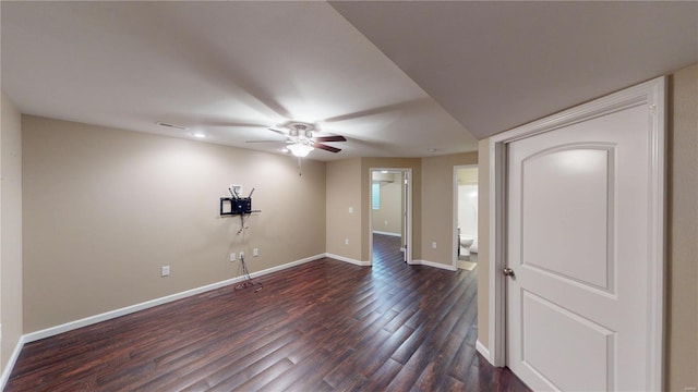 spare room with dark wood-style flooring, ceiling fan, and baseboards