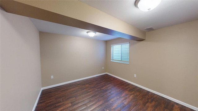 basement featuring dark wood-style flooring and baseboards