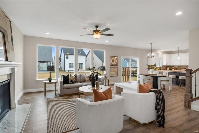 513 Beneficial Way, Saint Charles, MO 63304 - living area with healthy amount of natural light, wood finished floors, baseboards, a high end fireplace, and recessed lighting