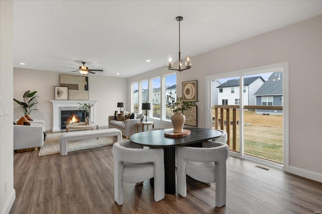 513 Beneficial Way, Saint Charles, MO 63304 - dining space with wood finished floors, a chandelier, a glass covered fireplace, baseboards, and ceiling fan
