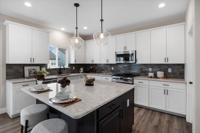 513 Beneficial Way, Saint Charles, MO 63304 - kitchen with stainless steel appliances, a sink, dark wood finished floors, white cabinets, and tasteful backsplash
