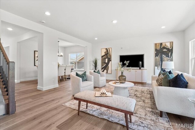 513 Beneficial Way, Saint Charles, MO 63304 - living room with stairway, light wood-type flooring, baseboards, recessed lighting, and a chandelier