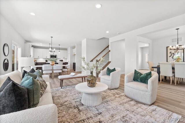 513 Beneficial Way, Saint Charles, MO 63304 - living area with light wood-style floors, a chandelier, stairs, recessed lighting, and baseboards
