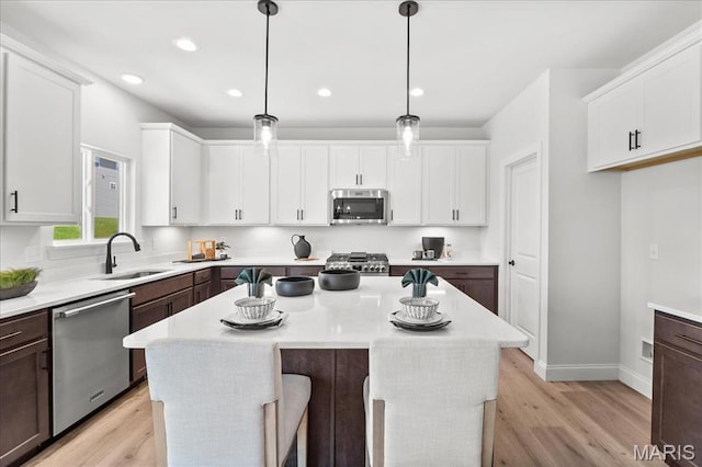 513 Beneficial Way, Saint Charles, MO 63304 - kitchen with stainless steel appliances, a sink, white cabinets, light countertops, and recessed lighting