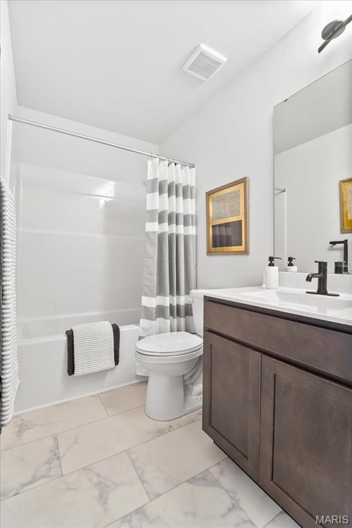 513 Beneficial Way, Saint Charles, MO 63304 - bathroom featuring marble look tiles, vanity, shower / bath combo with shower curtain, and toilet