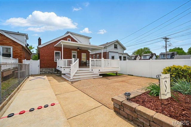 4355 Toenges Ave, Saint Louis, MO 63116 - view of front of property with a ceiling fan, brick siding, a fenced backyard, a deck, and a patio area