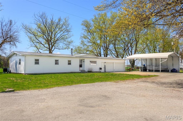2 S Circle Dr, Carlyle, IL 62231 - manufactured / mobile home featuring driveway, a front lawn, a detached carport, and a garage
