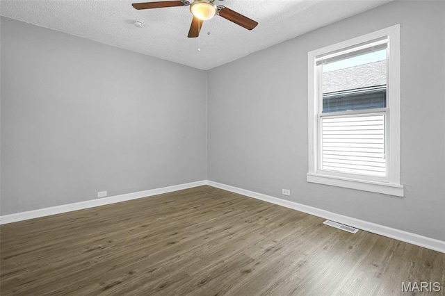 2430 Wallis Ave, Saint Louis, MO 63114 - spare room featuring wood finished floors, healthy amount of natural light, baseboards, ceiling fan, and a textured ceiling