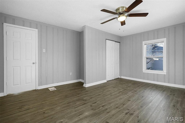 2430 Wallis Ave, Saint Louis, MO 63114 - unfurnished bedroom with dark wood-type flooring, a closet, ceiling fan, baseboards, and a textured ceiling