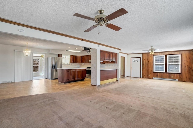 unfurnished living room with a baseboard radiator, ornamental molding, a ceiling fan, a textured ceiling, and a chandelier