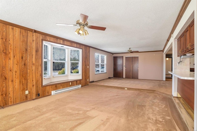 unfurnished living room with baseboard heating, ceiling fan, ornamental molding, plenty of natural light, and a textured ceiling