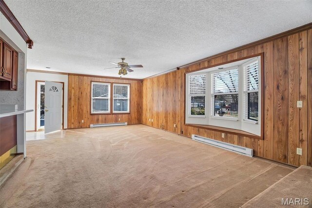 6072 Kingsway, House Springs, MO 63051 - unfurnished living room with a baseboard radiator, ornamental molding, wood walls, a ceiling fan, and baseboards