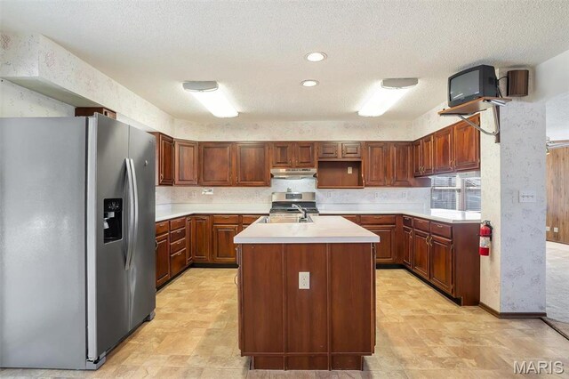 6072 Kingsway, House Springs, MO 63051 - kitchen with stainless steel appliances, under cabinet range hood, light countertops, an island with sink, and a sink