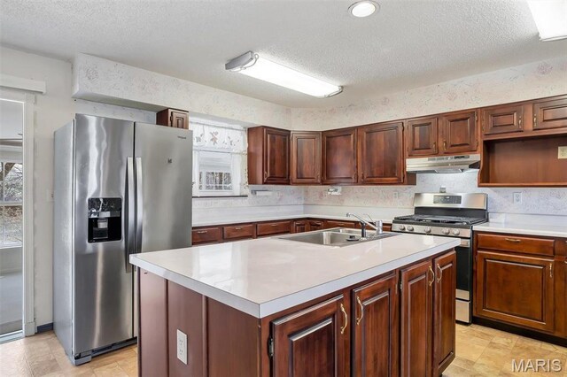 6072 Kingsway, House Springs, MO 63051 - kitchen with appliances with stainless steel finishes, a sink, under cabinet range hood, light countertops, and a textured ceiling