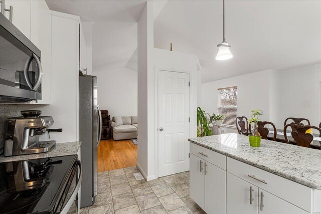 9 Amber Ridge Ct, High Ridge, MO 63049 - kitchen with stainless steel appliances, white cabinets, hanging light fixtures, lofted ceiling, and light stone counters