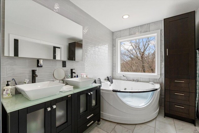 9 Amber Ridge Ct, High Ridge, MO 63049 - full bathroom featuring tile walls, marble finish flooring, a jetted tub, and double vanity