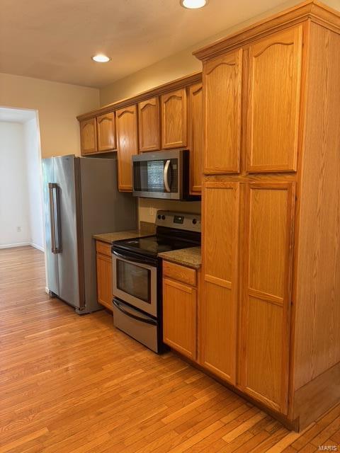 708 Michael St, Ofallon, IL 62269 - kitchen featuring stainless steel appliances, light wood-type flooring, recessed lighting, brown cabinets, and dark countertops