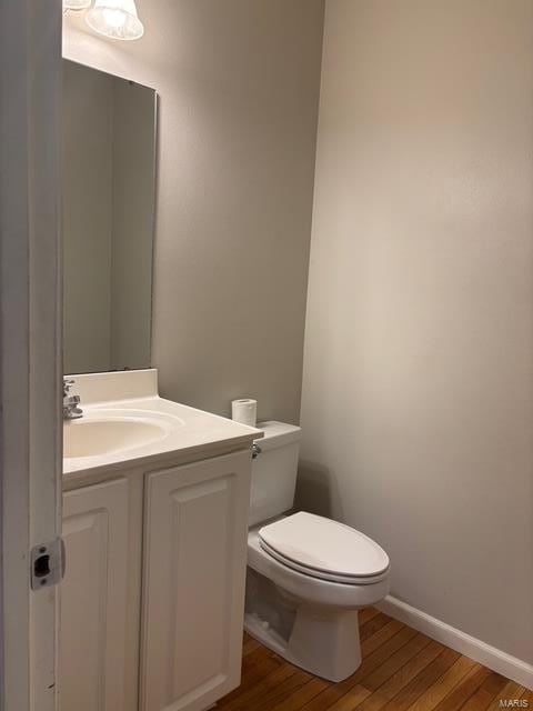 708 Michael St, Ofallon, IL 62269 - half bathroom with wood finished floors, toilet, vanity, and baseboards