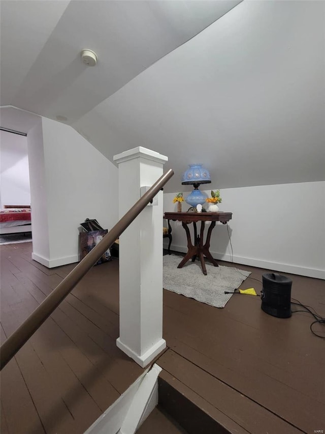 staircase with lofted ceiling, hardwood / wood-style floors, and baseboards