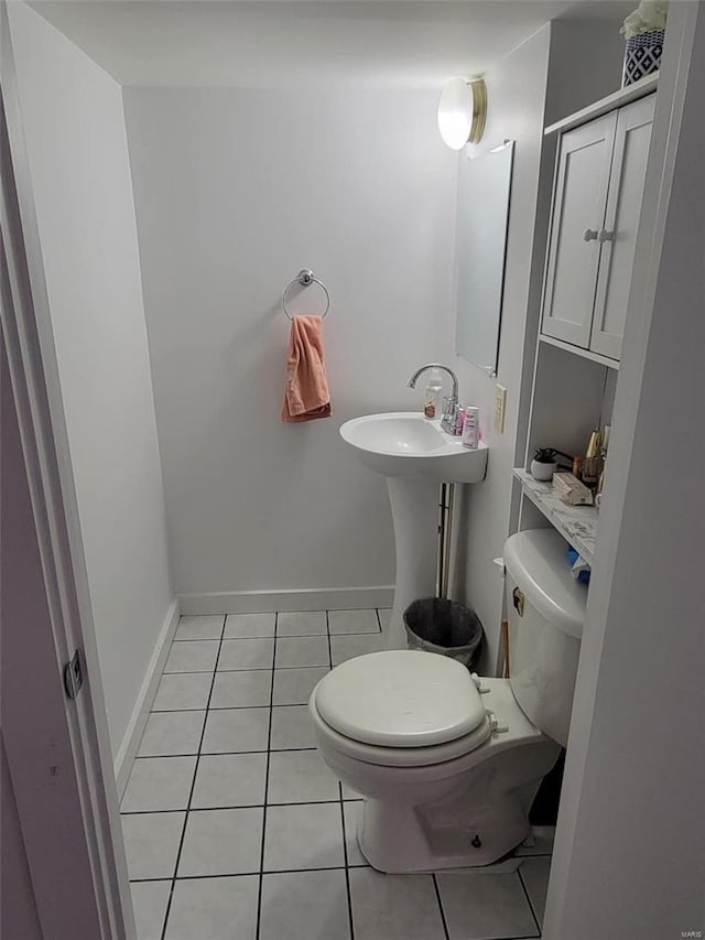 half bath featuring toilet, tile patterned floors, and baseboards