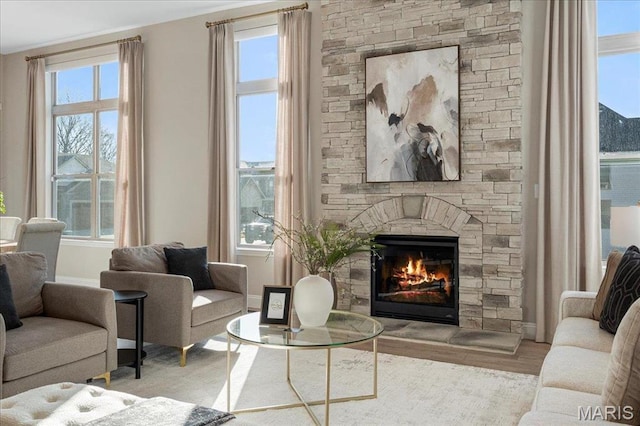 504 Coppice Ct, Wentzville, MO 63385 - living room with a stone fireplace, baseboards, and wood finished floors