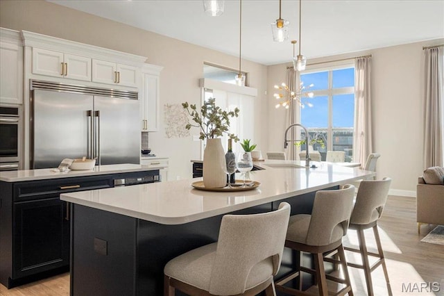 504 Coppice Ct, Wentzville, MO 63385 - kitchen with a sink, a center island with sink, stainless steel appliances, and light countertops