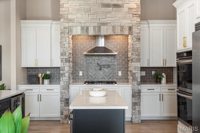 504 Coppice Ct, Wentzville, MO 63385 - kitchen featuring wall chimney exhaust hood, backsplash, stainless steel appliances, and light wood-style floors