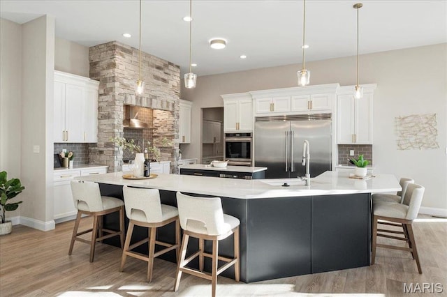 504 Coppice Ct, Wentzville, MO 63385 - kitchen featuring stainless steel appliances, a spacious island, decorative backsplash, light wood-style floors, and recessed lighting