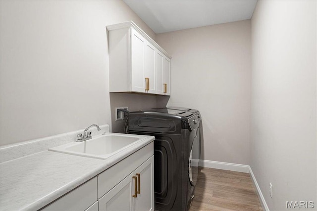 504 Coppice Ct, Wentzville, MO 63385 - washroom featuring cabinet space, washing machine and dryer, baseboards, and light wood-style floors