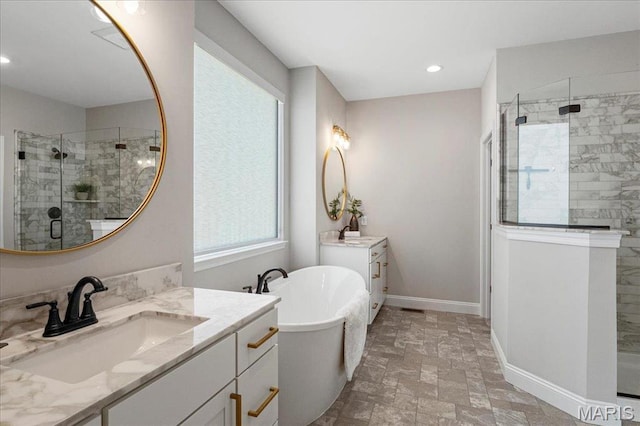 504 Coppice Ct, Wentzville, MO 63385 - bathroom with a shower stall, a freestanding bath, two vanities, recessed lighting, and stone finish floors