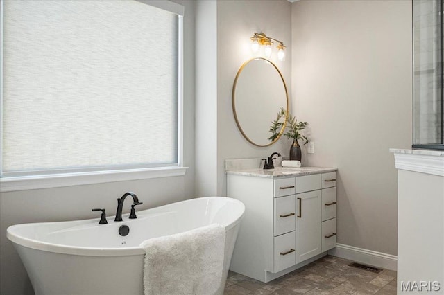 504 Coppice Ct, Wentzville, MO 63385 - bathroom with vanity, a freestanding tub, baseboards, and stone finish floors