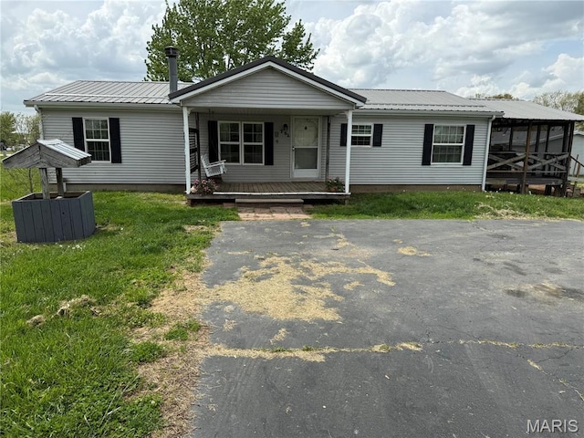 751 High St, Edgar Springs, MO 65462 - view of front facade featuring covered porch, metal roof, and a front lawn