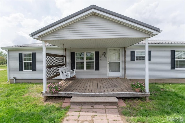 751 High St, Edgar Springs, MO 65462 - view of front of home with a front lawn, metal roof, and a wooden deck