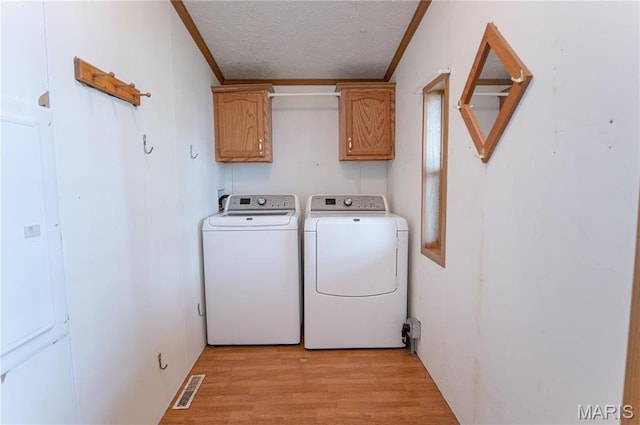751 High St, Edgar Springs, MO 65462 - washroom with cabinet space, a textured ceiling, washing machine and dryer, light wood-style floors, and ornamental molding