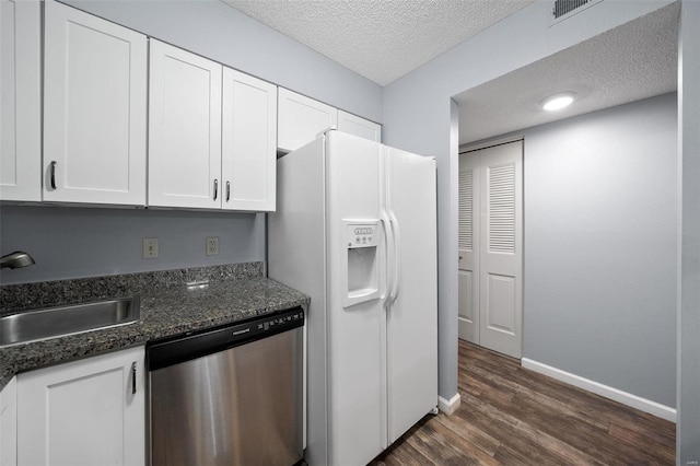 1593 Thrush Ter, Brentwood, MO 63144 - kitchen with dishwasher, a textured ceiling, white refrigerator with ice dispenser, dark wood-style flooring, and white cabinetry