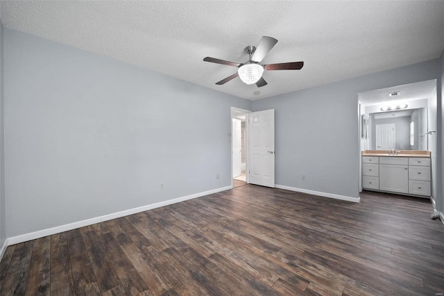 1593 Thrush Ter, Brentwood, MO 63144 - unfurnished bedroom featuring dark wood-type flooring, baseboards, a sink, a textured ceiling, and ensuite bathroom