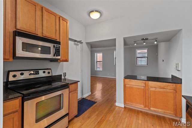 5653 Waterman Blvd Unit 3N, Saint Louis, MO 63112 - kitchen with stainless steel appliances, light wood finished floors, baseboards, and brown cabinets