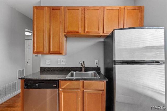 5653 Waterman Blvd Unit 3N, Saint Louis, MO 63112 - kitchen with appliances with stainless steel finishes, a sink, wood finished floors, baseboards, and brown cabinetry