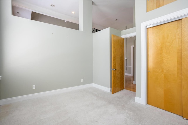 unfurnished bedroom with carpet floors, baseboards, a closet, recessed lighting, and crown molding