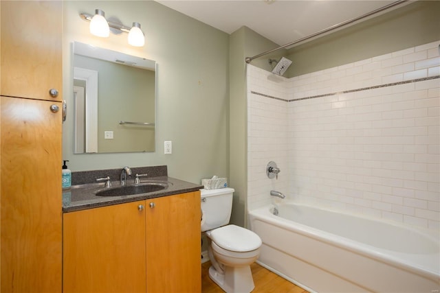 bathroom featuring toilet, tub / shower combination, wood finished floors, and vanity