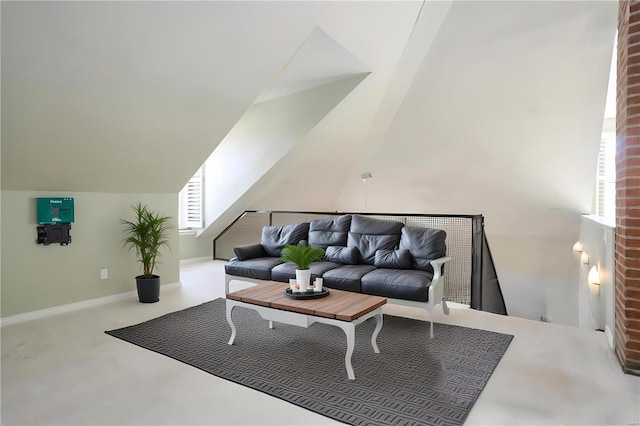 living area featuring lofted ceiling and baseboards