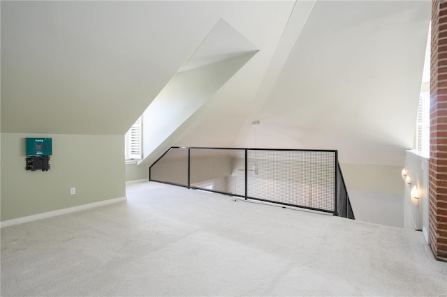 additional living space featuring carpet flooring, lofted ceiling, and baseboards