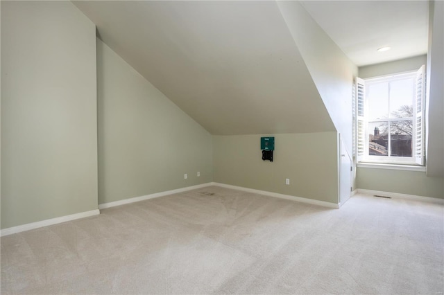 bonus room with light carpet, baseboards, and vaulted ceiling