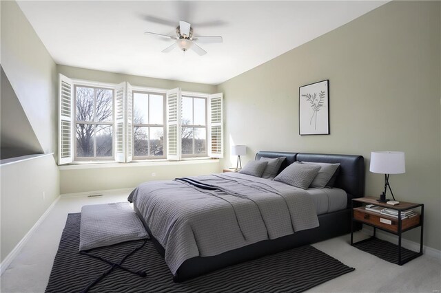 carpeted bedroom featuring baseboards and a ceiling fan