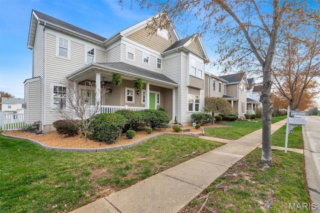 victorian house with a porch and a front lawn