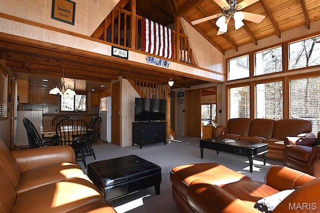 carpeted living room featuring high vaulted ceiling, ceiling fan, a chandelier, wooden ceiling, and beam ceiling